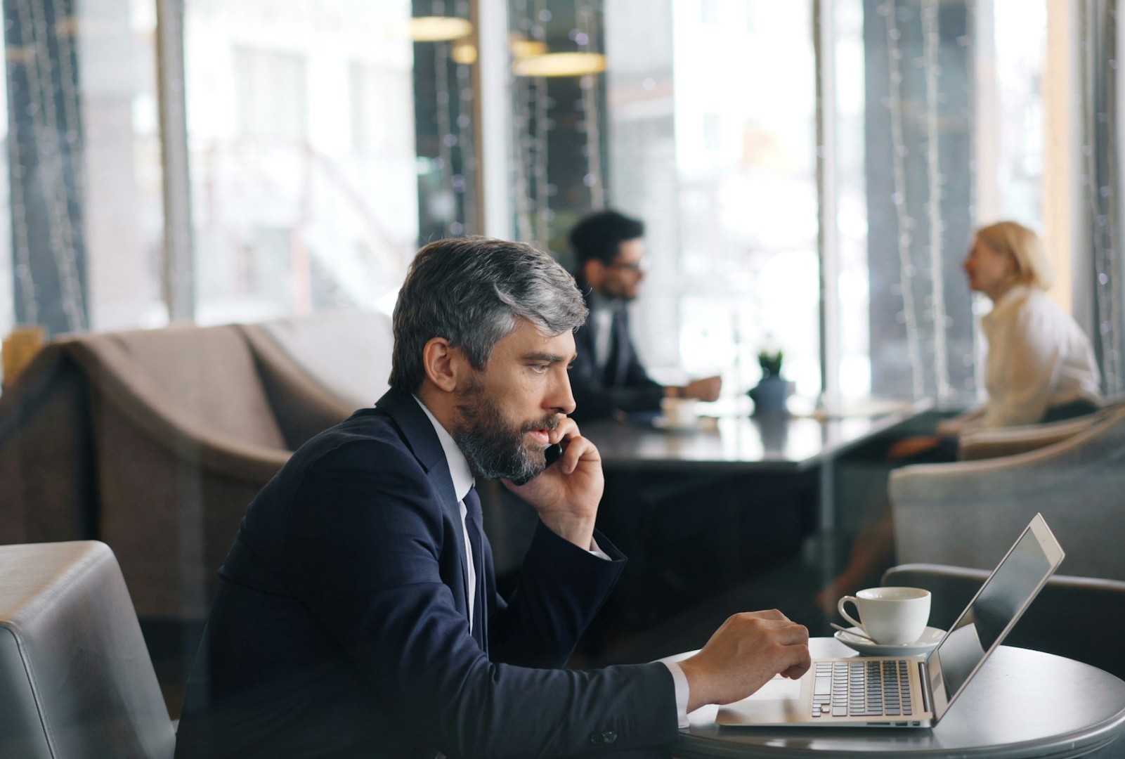 businessman talking on his phone and looking at his laptop